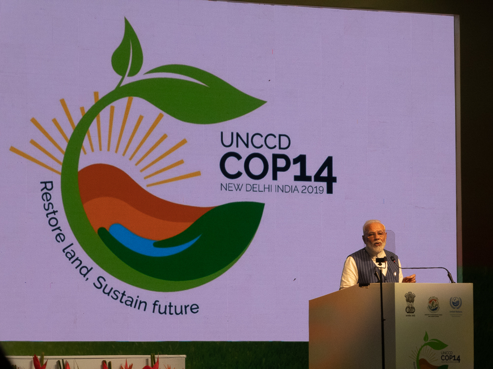 Narenda Modiam Rednerpult, hinter ihm Powerpoint mit Logo der COP 14