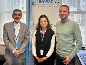 Photo of the Panel in front of a UNOSSC Poster