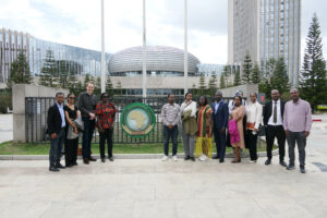 Photo: Participants posing in front of the logo of the African Union outside during their visit to the GIZ African Union office.