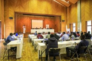 Photo: Eindrücke von unserem Restitution Workshop in Nairobi. Photo: Impressions from our restitution workshop in Nairobi. Photographed from behind towards the screen, with the participants sitting at the tables.