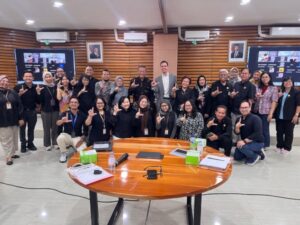 Group photo of the MGG Jakarta Network Group with a hand gesture representing the letter “L.”