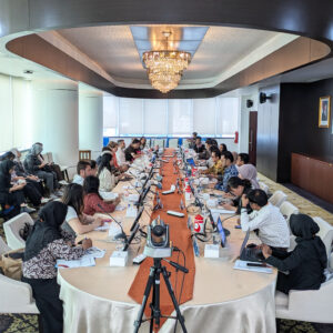 Photo: Workshop at the MGG Conference in Jakarta, with participants seated around a large oval table.